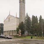 esterno: prospetto principale, campanile e la scultura di Santa Barbara realizzata da Caron