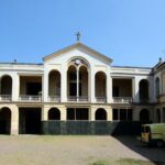 Esterno. Veduta lato est del cortile del complesso di S. Maria Teodote. L'ingresso della cappella è posto al centro della balconata al primo piano.